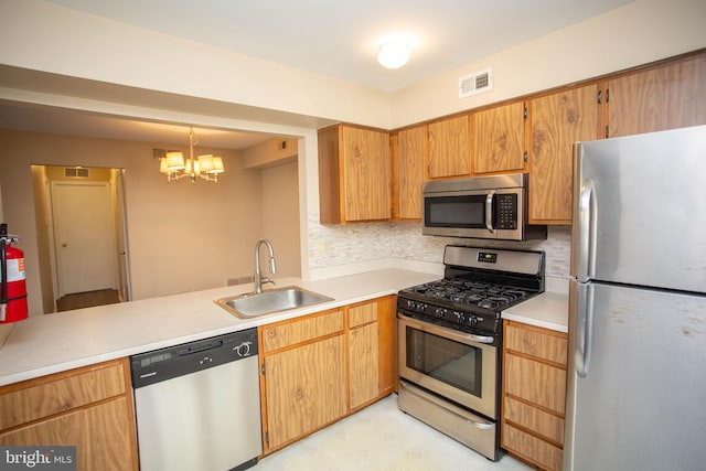 kitchen with visible vents, a sink, stainless steel appliances, light countertops, and backsplash