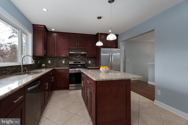 kitchen featuring wall chimney exhaust hood, appliances with stainless steel finishes, a sink, and tasteful backsplash