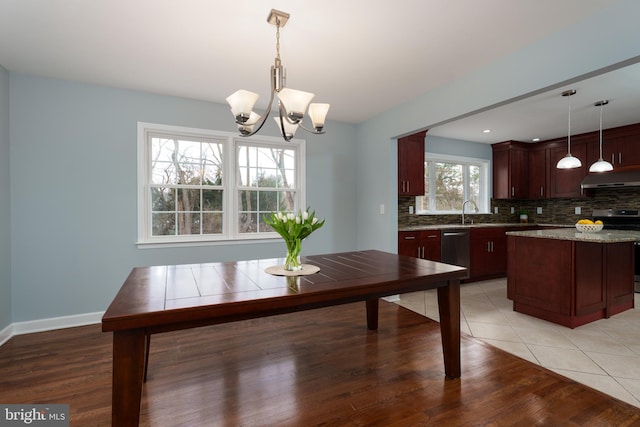 dining area with baseboards, a chandelier, and light tile patterned flooring