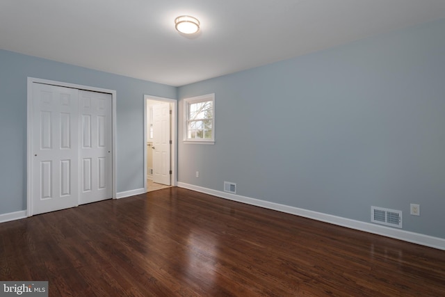 unfurnished bedroom with baseboards, visible vents, and wood finished floors