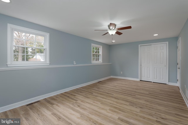 unfurnished bedroom with light wood-type flooring, a closet, visible vents, and baseboards