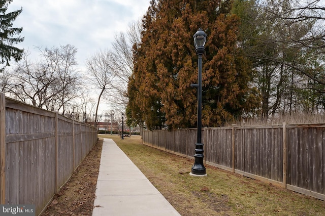 view of property's community with fence and a lawn