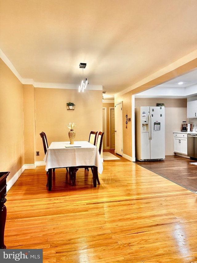 dining area featuring baseboards and light wood finished floors