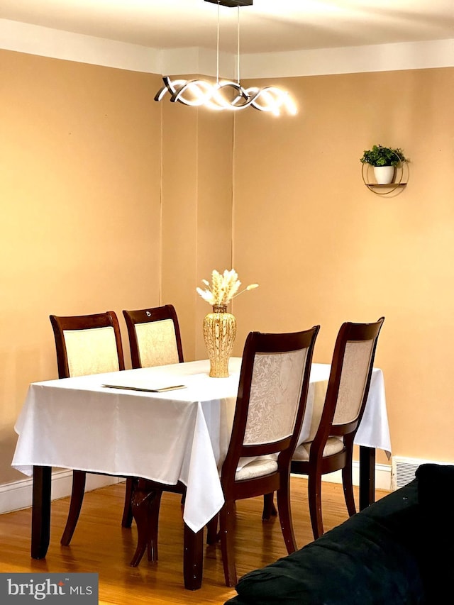 dining space featuring visible vents, baseboards, and wood finished floors