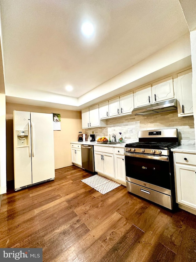 kitchen featuring white cabinets, dark wood-style floors, stainless steel appliances, light countertops, and under cabinet range hood