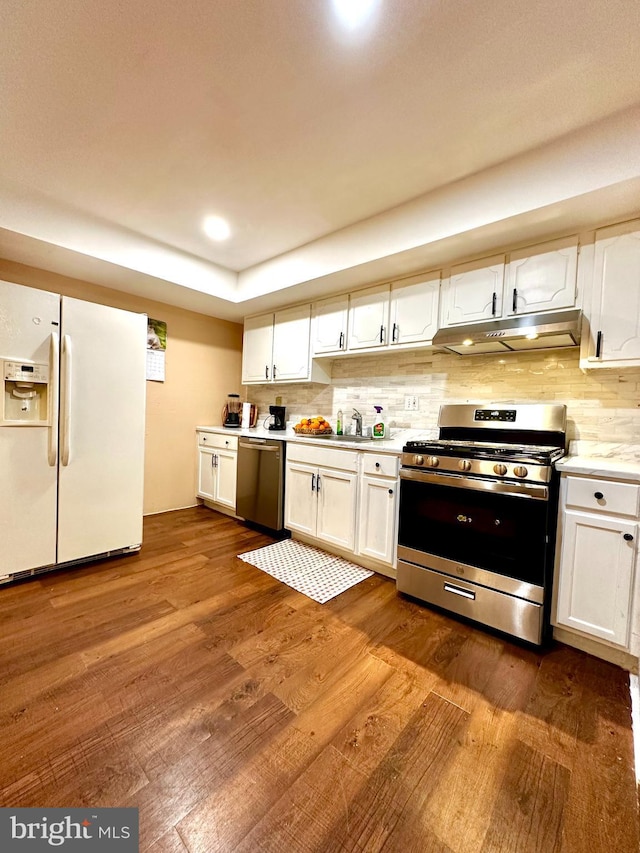 kitchen featuring under cabinet range hood, stainless steel appliances, dark wood-style flooring, white cabinets, and light countertops