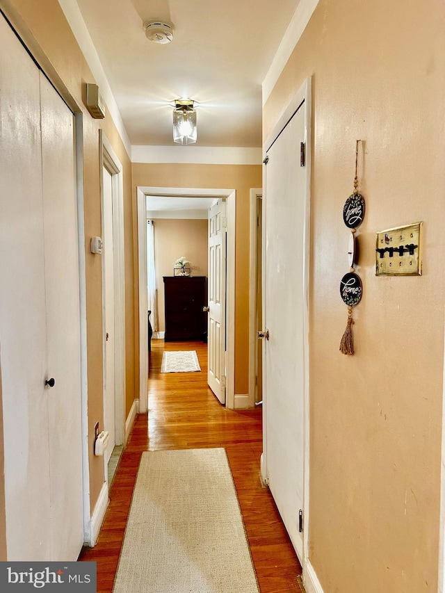 hall featuring baseboards and wood finished floors