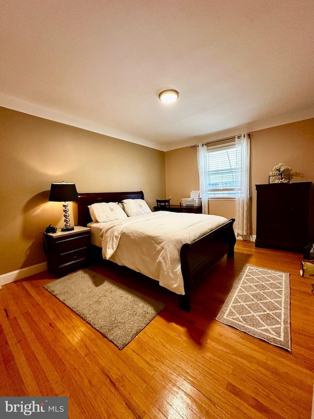 bedroom featuring wood-type flooring and baseboards