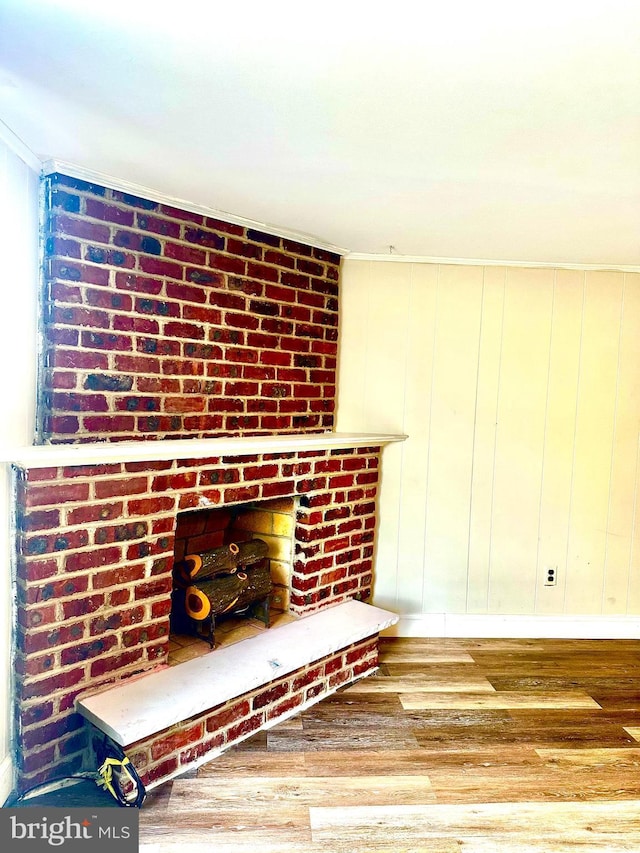 room details featuring a fireplace, wood finished floors, and baseboards