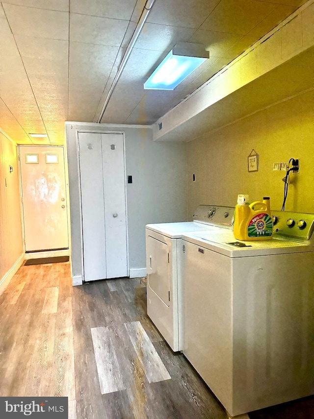 laundry area featuring laundry area, independent washer and dryer, wood finished floors, and baseboards