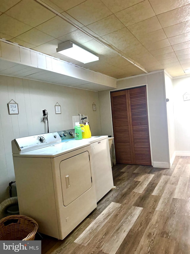 laundry area with laundry area, separate washer and dryer, and wood finished floors