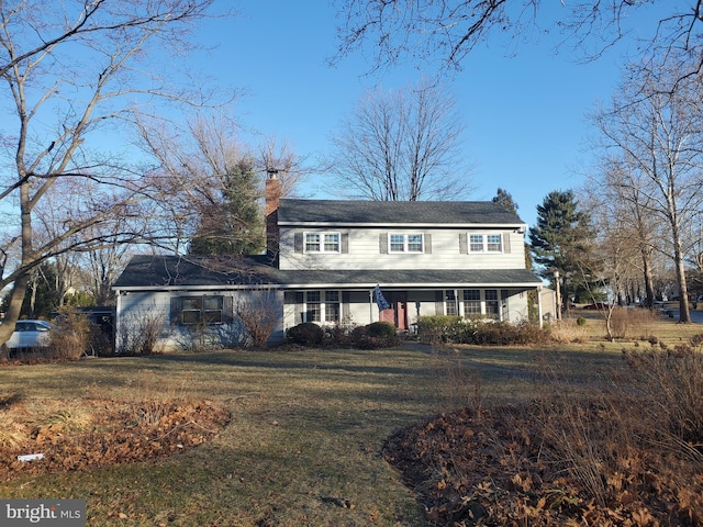 view of front facade with a front yard and a chimney