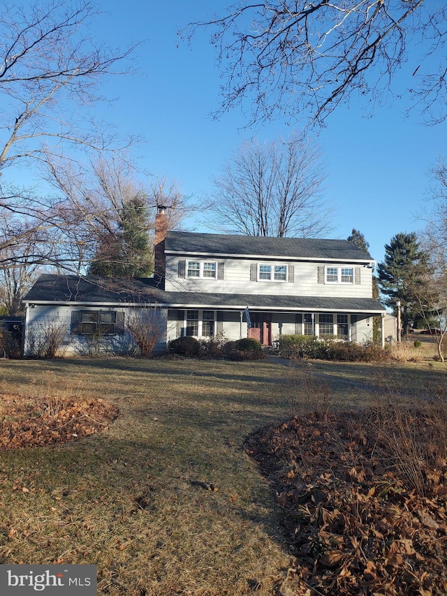 view of front of house with a chimney and a front lawn