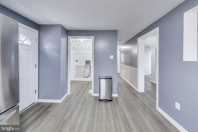 foyer with baseboards and wood finished floors