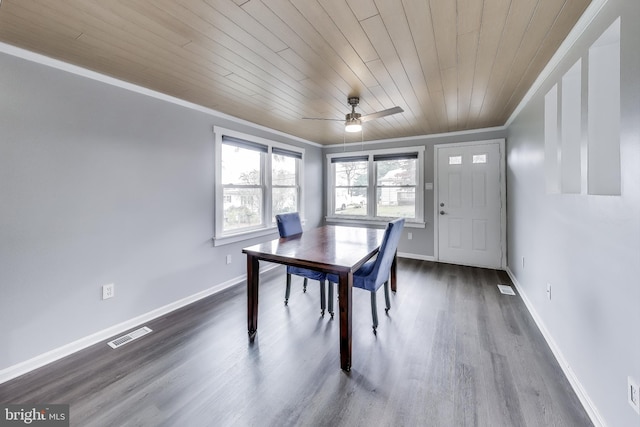 unfurnished dining area with baseboards, dark wood-type flooring, visible vents, and crown molding