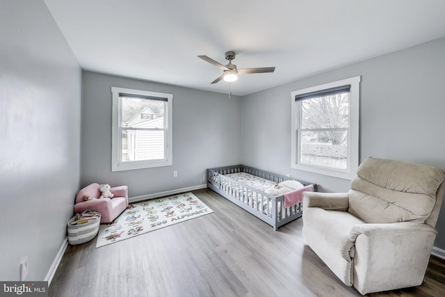 bedroom featuring ceiling fan, baseboards, and wood finished floors