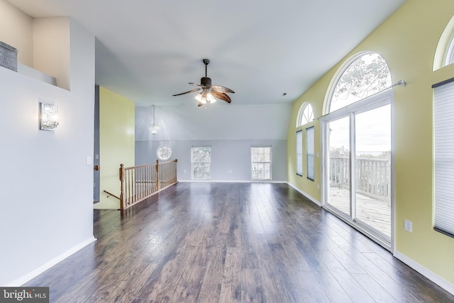 unfurnished living room featuring a ceiling fan, baseboards, and wood finished floors