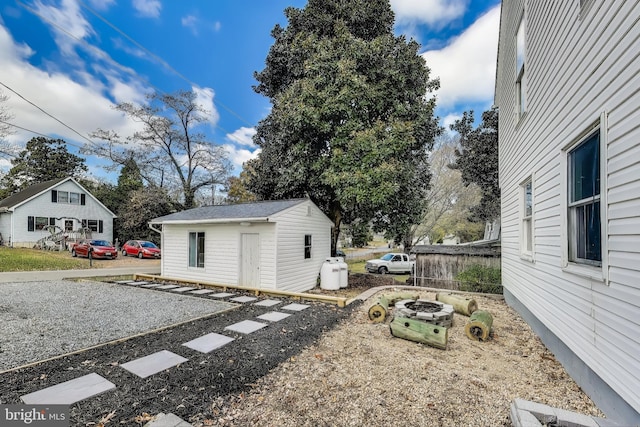 view of yard with an outdoor fire pit, an outdoor structure, and fence