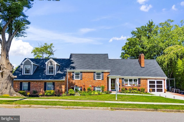 split level home featuring a garage, driveway, brick siding, and a front yard