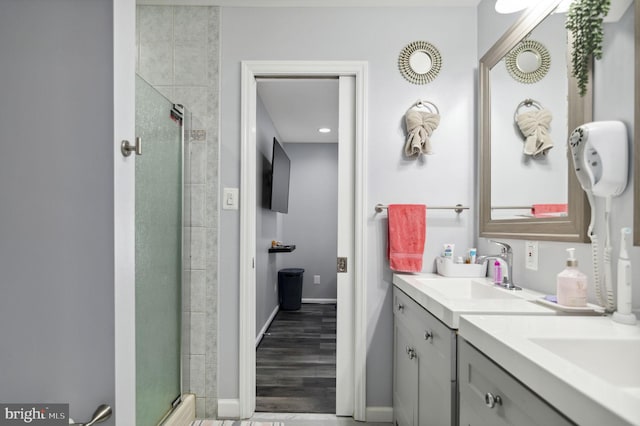 bathroom featuring a shower stall, baseboards, and vanity