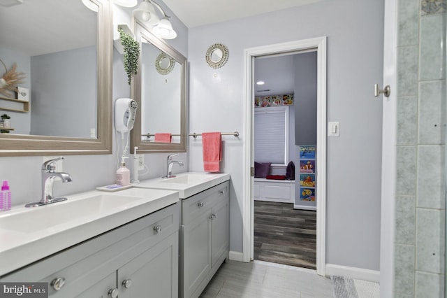 ensuite bathroom with ensuite bath, vanity, and baseboards