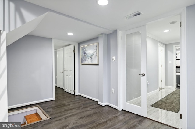 corridor featuring recessed lighting, wood finished floors, visible vents, baseboards, and ornamental molding