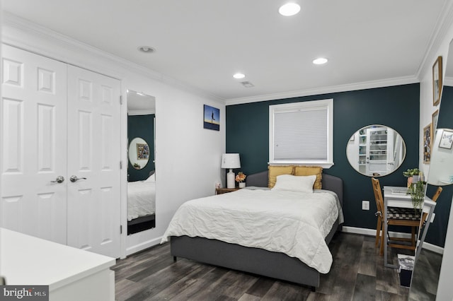 bedroom with a closet, crown molding, baseboards, and wood finished floors