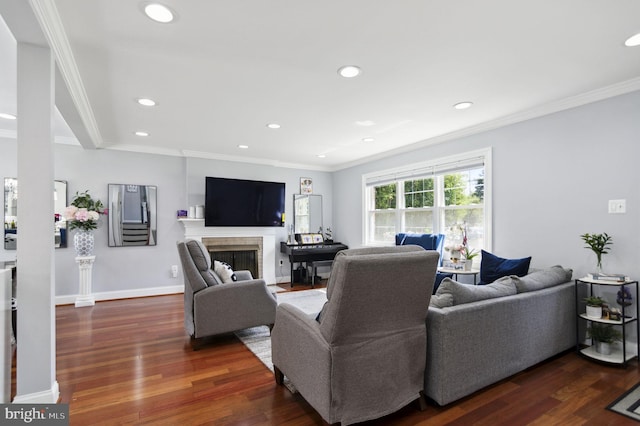 living room featuring baseboards, a fireplace, wood finished floors, and crown molding