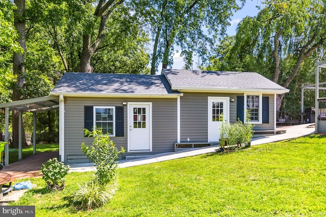 view of front of home featuring a front lawn and a shingled roof