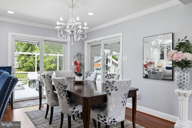 dining area featuring a chandelier, ornamental molding, baseboards, and wood finished floors