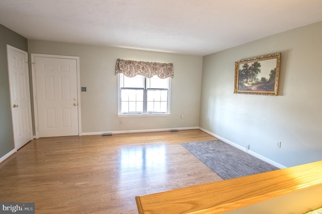 interior space featuring visible vents, baseboards, and wood finished floors