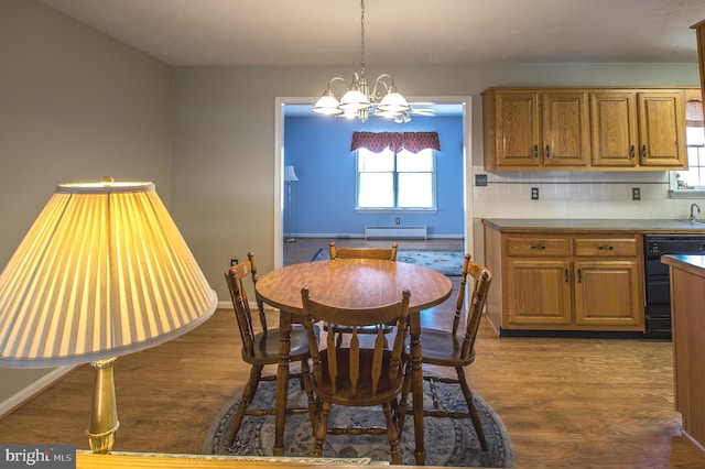 dining space featuring a notable chandelier, baseboards, baseboard heating, and dark wood-type flooring