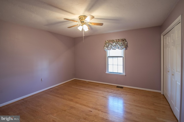 unfurnished bedroom with light wood-style floors, baseboards, and a closet