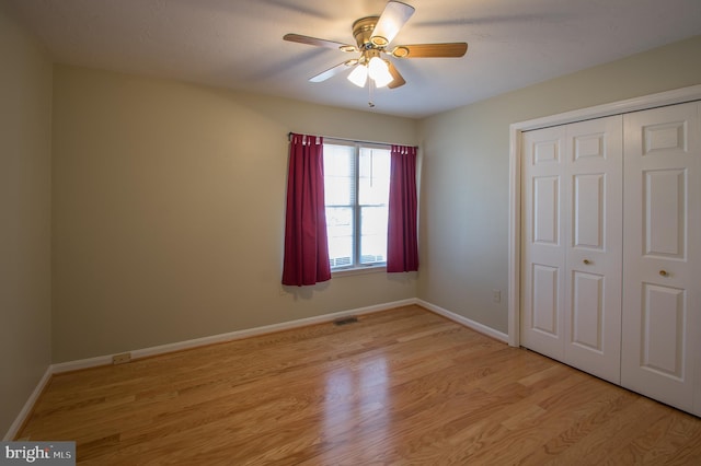 unfurnished bedroom with ceiling fan, light wood finished floors, a closet, and baseboards