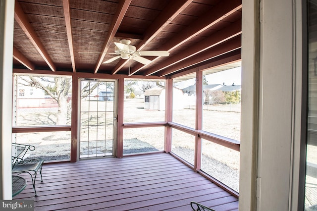 unfurnished sunroom with beam ceiling, wood ceiling, and a ceiling fan