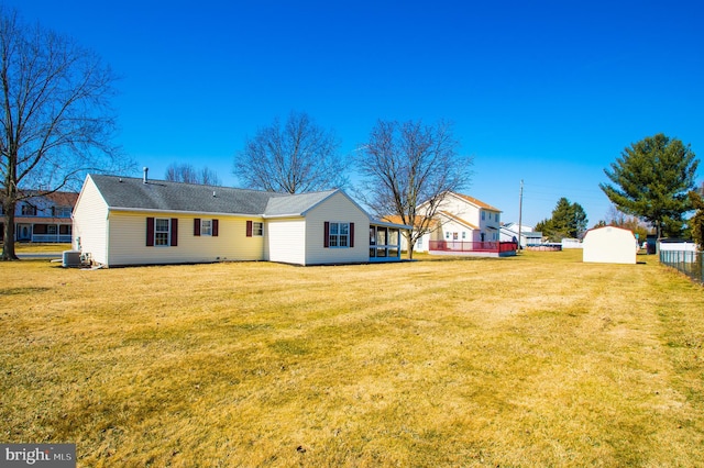 back of property with a lawn, fence, and central air condition unit