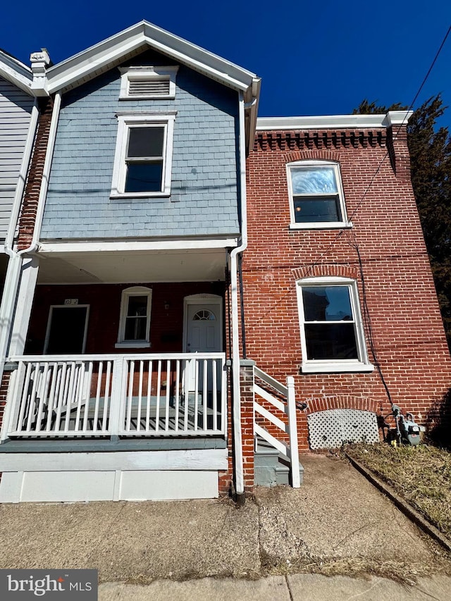 multi unit property featuring covered porch and brick siding