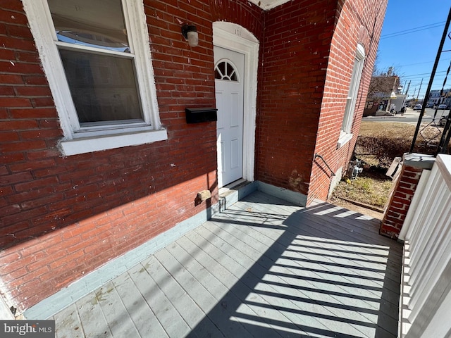 entrance to property featuring brick siding