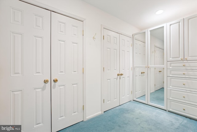 interior space featuring light carpet and two closets