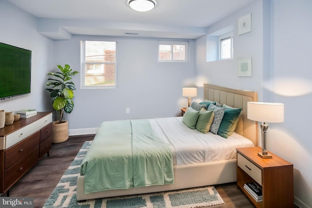 bedroom featuring baseboards and dark wood finished floors