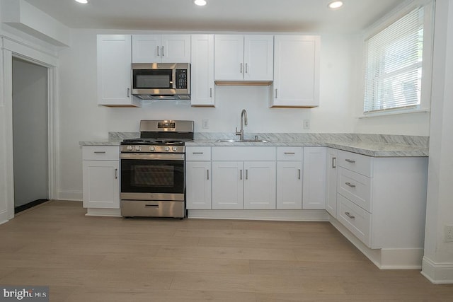 426 Hampden Rd, Upper Darby, PA 19082 - kitchen featuring appliances with stainless steel finishes, a sink, white cabinets, recessed lighting, and light wood-style floors