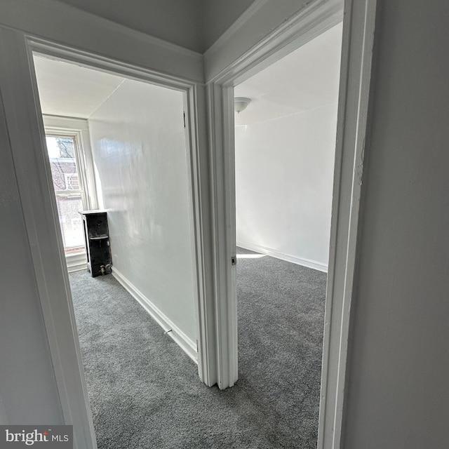 corridor featuring carpet flooring and baseboards