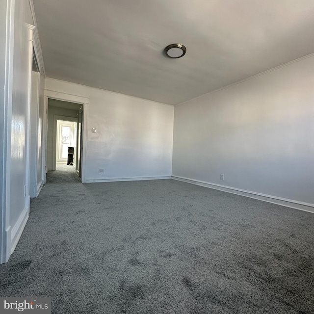 carpeted empty room featuring baseboards