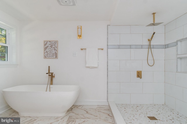 bathroom with marble finish floor, a tile shower, baseboards, and a freestanding tub