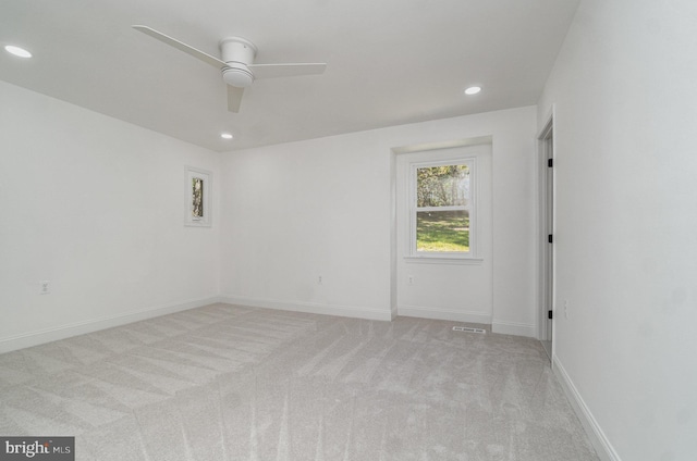 empty room with visible vents, baseboards, a ceiling fan, light colored carpet, and recessed lighting