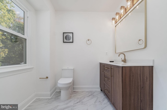 bathroom featuring marble finish floor, toilet, vanity, and baseboards