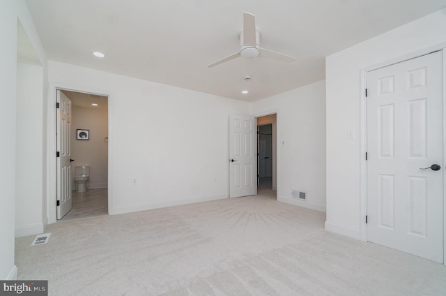 unfurnished bedroom with ensuite bath, carpet flooring, visible vents, and baseboards