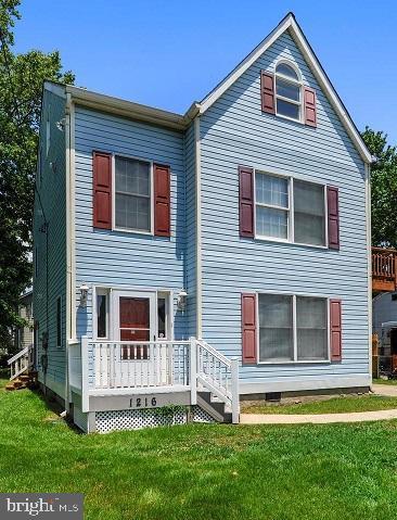 view of front of property with a wooden deck and a front yard