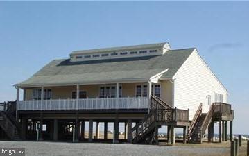 view of front of home with stairs, a carport, and driveway