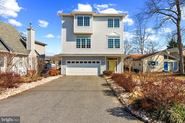 view of front of property featuring an attached garage and aphalt driveway